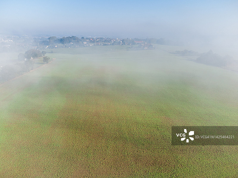 雾中耕地和村庄航拍图图片素材