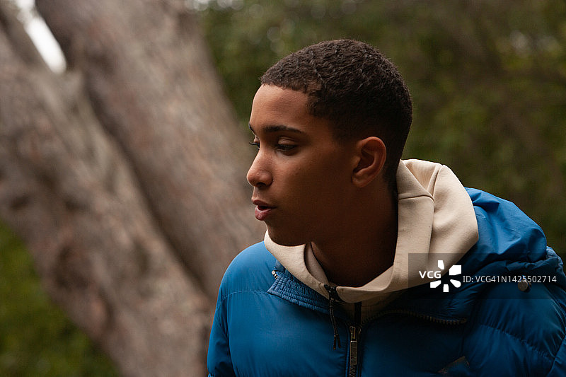 在户外看向一侧的青少年男人侧写图片素材