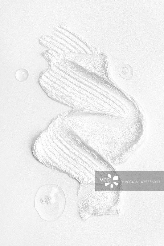 白色背景上的三滴爽肤水和白色面霜，含有聚谷氨酸、神经酰胺和多种维生素的美容产品，自上而下的微距摄影图片素材