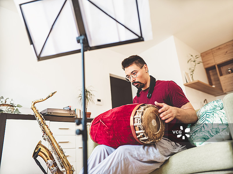 年轻男人在家练习塔布拉鼓图片素材