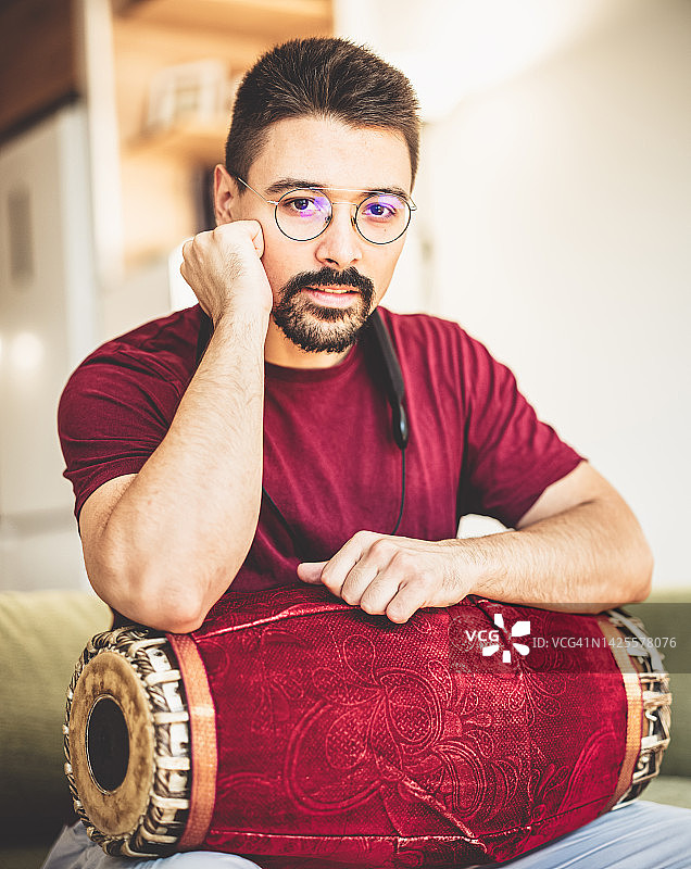 年轻男人在家练习塔布拉鼓图片素材