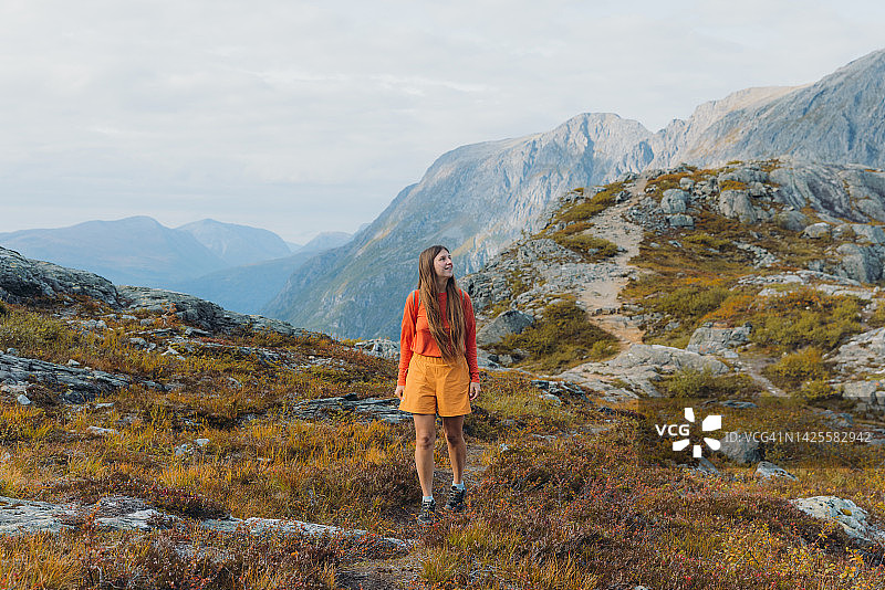 女徒步旅行者在挪威山区欣赏秋景图片素材