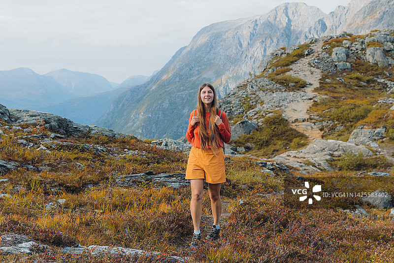 女徒步旅行者在挪威山区欣赏秋景图片素材