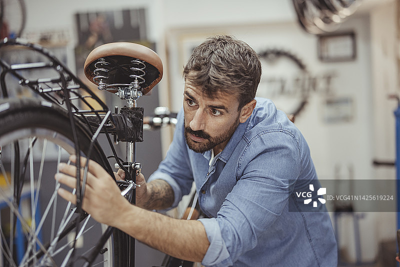 在自行车修理店工作的男人图片素材