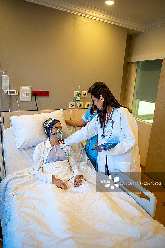 亚洲女医生和护士检查在医院病床上康复的病人图片素材