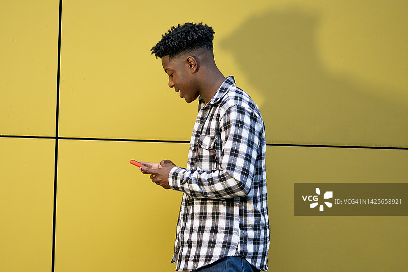 年轻黑人男子在街上用手机与朋友聊天图片素材