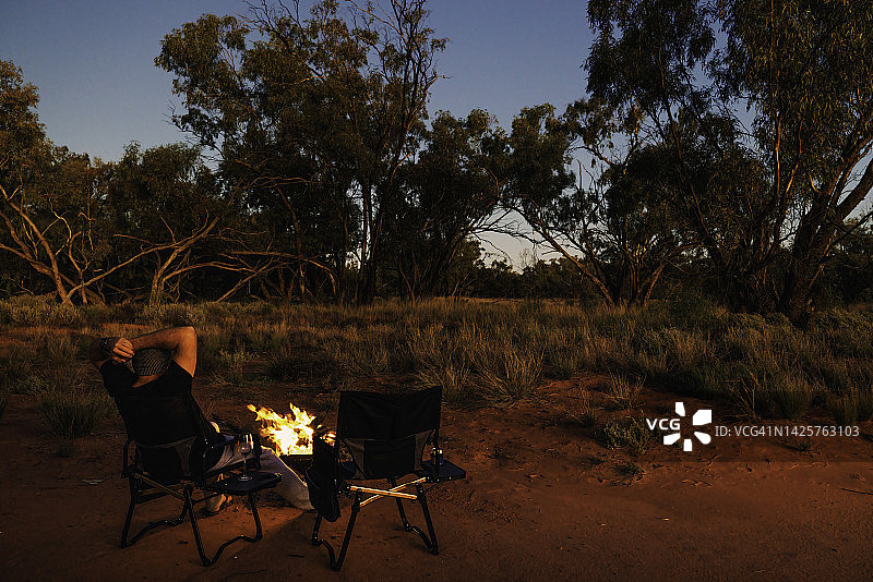 男子坐在篝火旁图片素材