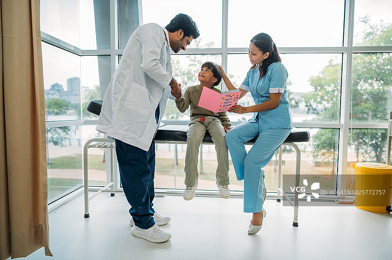 快乐的亚洲儿童收到医生和医务人员赠送的慰问卡礼物图片素材