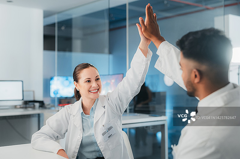 科学家在实验室里击掌庆祝目标达成，医生庆祝医学研究成功图片素材