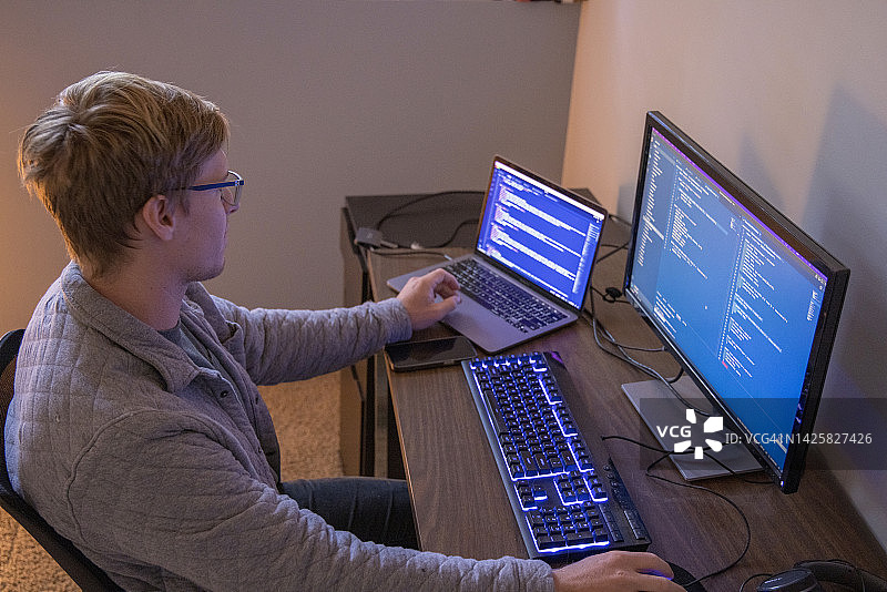 年轻男人使用多台电脑进行网站代码开发图片素材