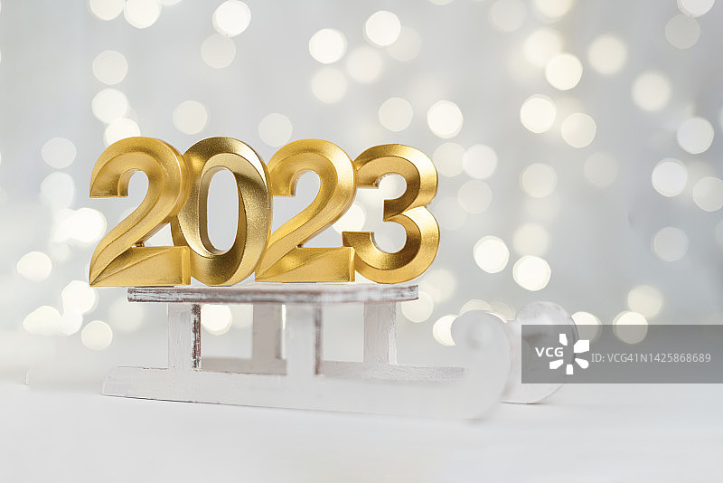2023新年金色数字符号在灯光散景的背景上图片素材