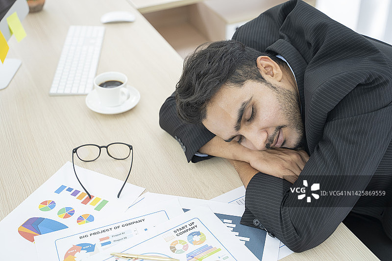 商人在办公室的桌子上睡觉图片素材