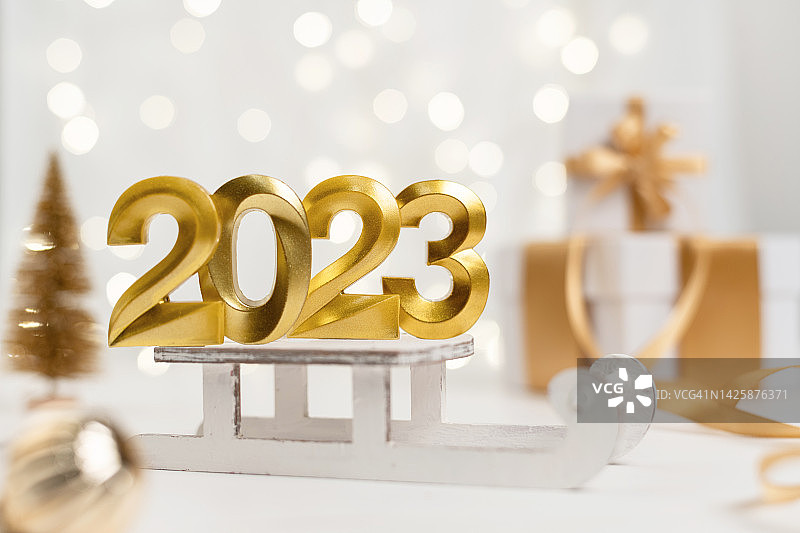 2023新年金色数字符号在灯光散景的背景上图片素材