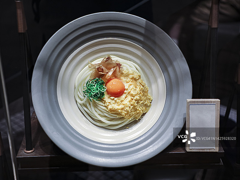 釜玉乌冬面食物模型，大碗中带有生鸡蛋的乌冬面图片素材