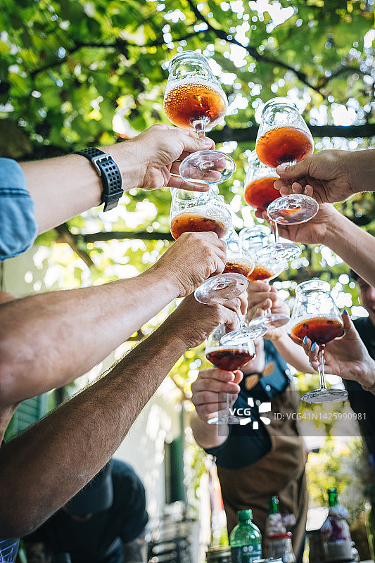 举起啤酒杯敬酒的手臂的仰视角度图片素材
