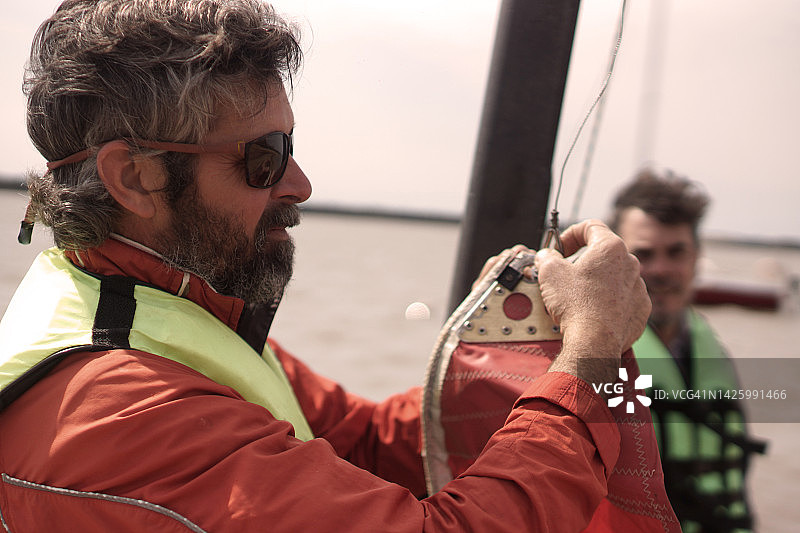 在海滩上准备扬帆起航的男人图片素材