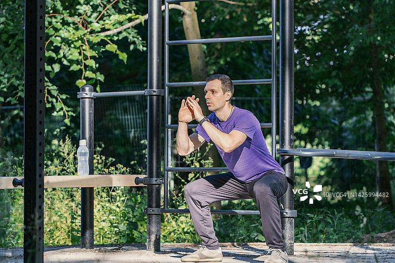 户外深蹲——清晨专注锻炼的健壮男子图片素材