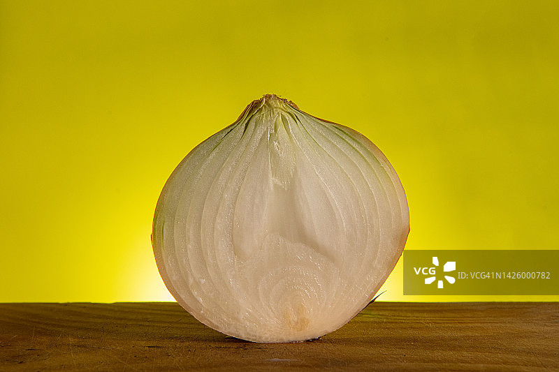 彩色背景上的切半洋葱图片素材