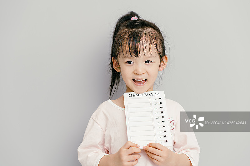 快乐地拿着待办事项清单的亚洲女孩图片素材