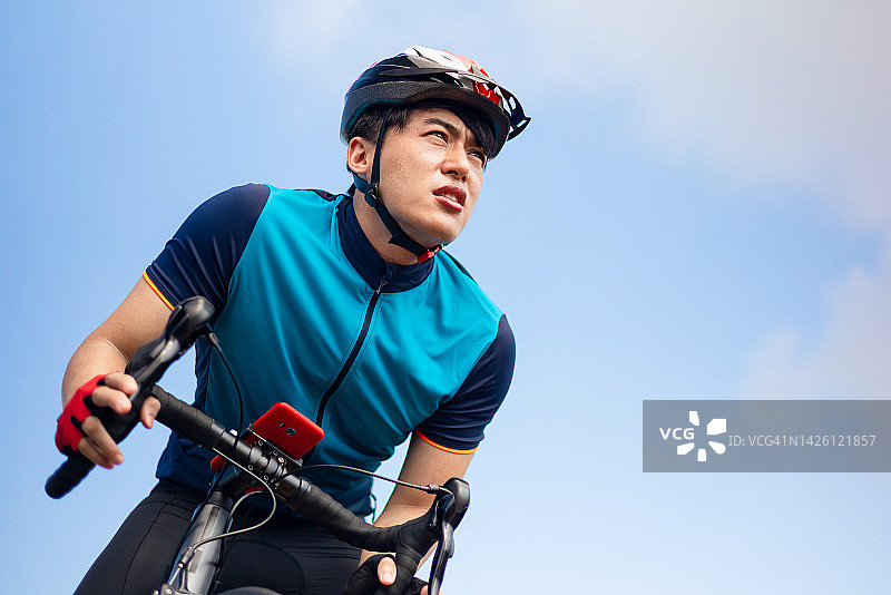 骑自行车的亚洲青年男人图片素材
