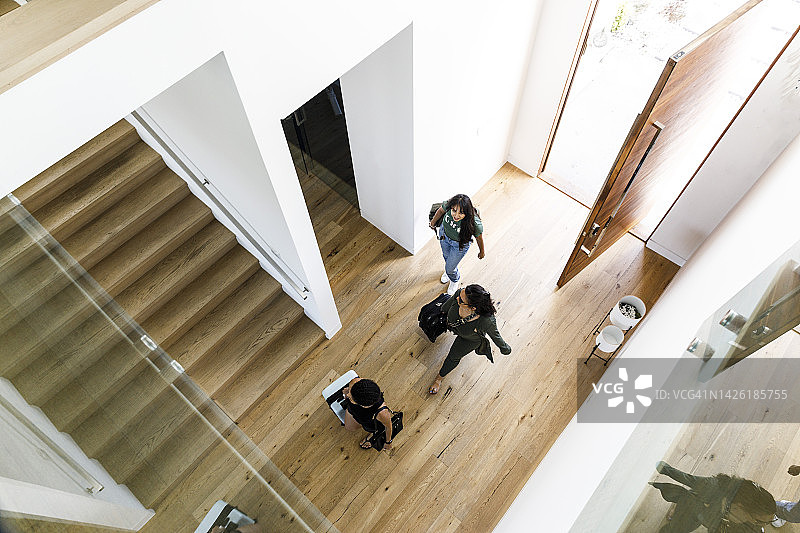 俯视角度拍摄的进入度假屋的女性朋友图片素材