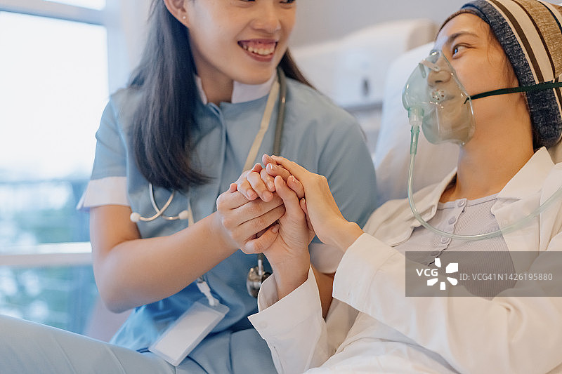 医护人员握着病床上病人的手图片素材