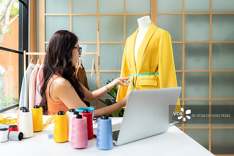 亚洲女装设计师在展厅工作图片素材