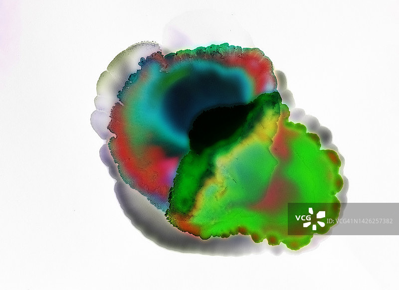 白色表面上滑落的彩色液体污渍图片素材