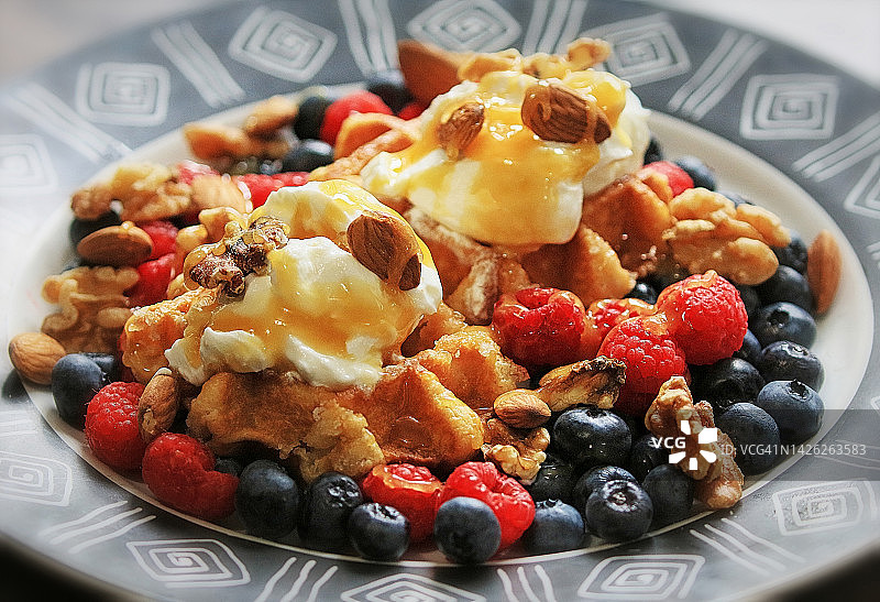 覆盆子、蓝莓、酸奶、杏仁、核桃和蜂蜜华夫饼图片素材