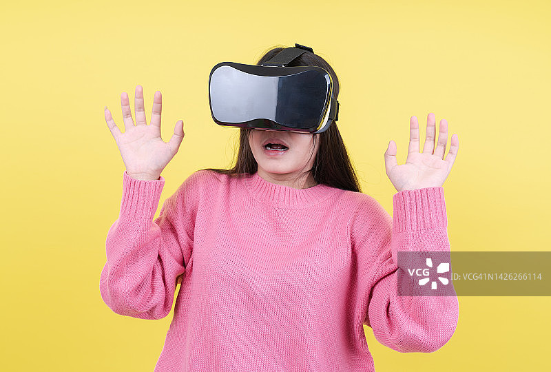 元宇宙：佩戴VR眼镜的女人，虚拟现实AI概念，黄色背景图片素材