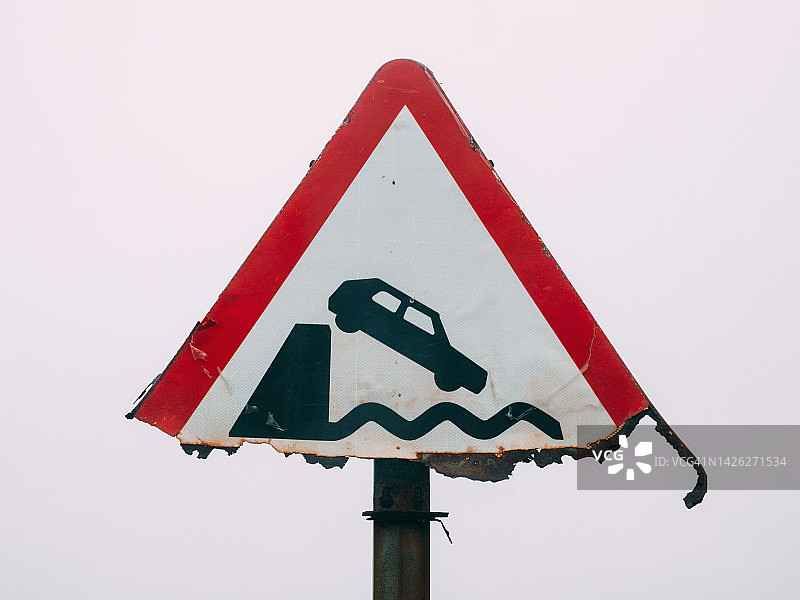 损坏的警告交通标志，无保护的码头或河岸图片素材