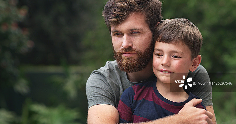 父亲与患有自闭症的儿子在公园、后院或公共花园拥抱图片素材