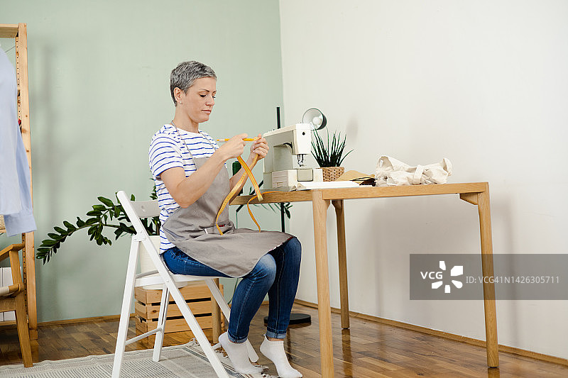 女人在她的裁缝工作室缝纫衣服图片素材