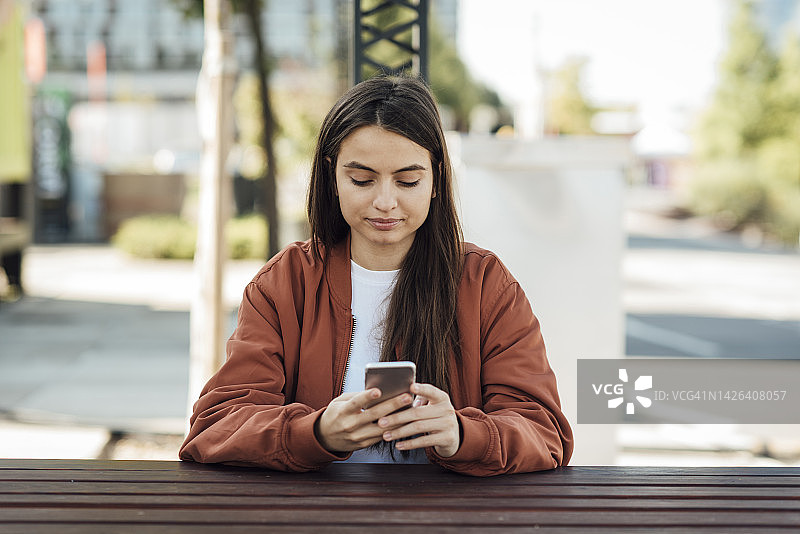 女孩在手机上发短信图片素材