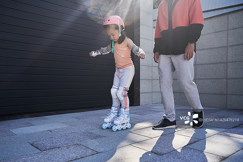 阳光下，父亲教女儿滑旱冰图片素材