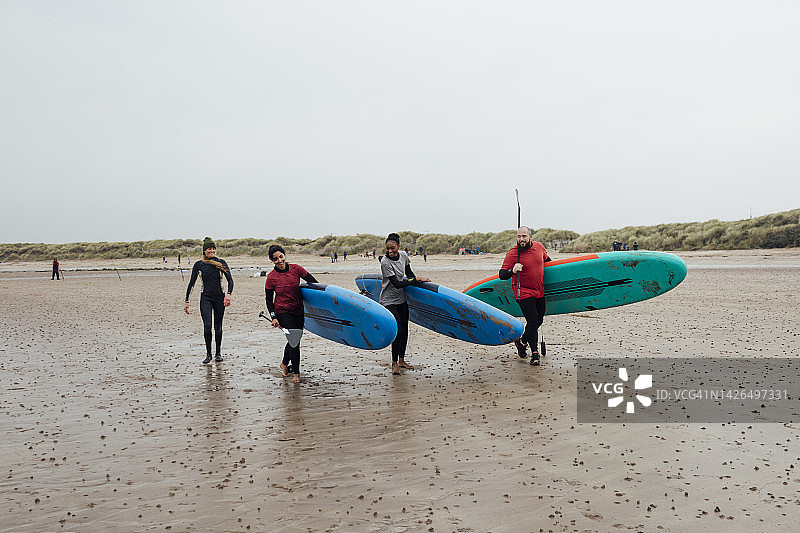 在海滩上与桨板一起散步图片素材