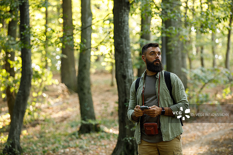 迷路的背包客在森林里寻找熟悉的踪迹图片素材