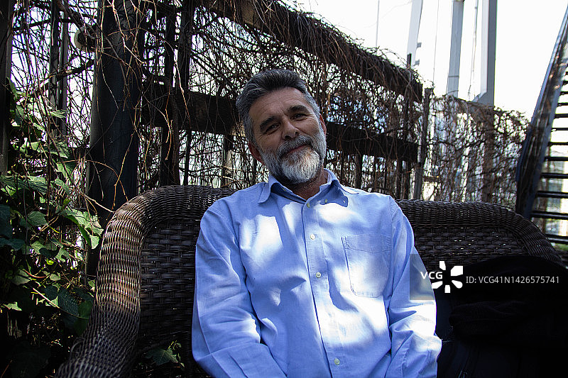 在餐厅花园里放松的成熟男人图片素材
