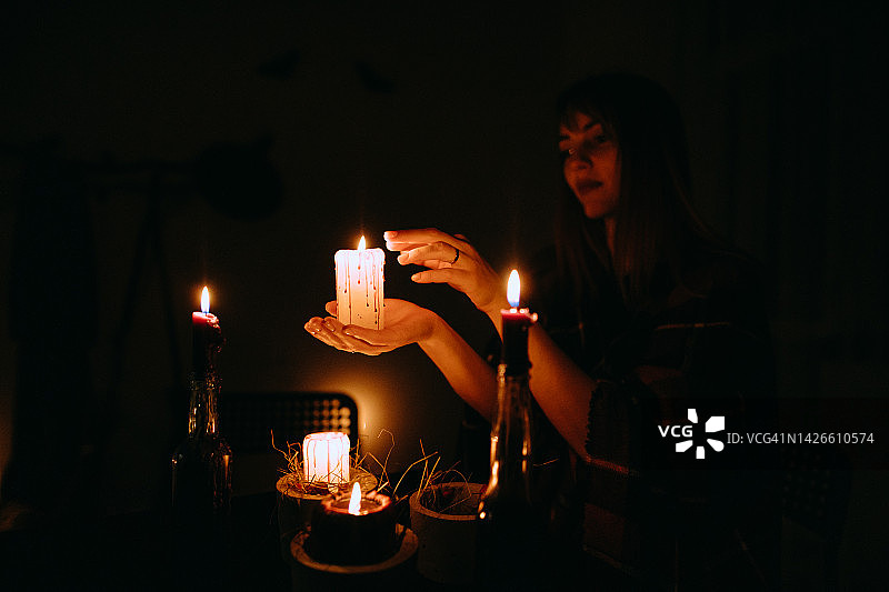 女人手在黑暗中拿着蜡烛过万圣节图片素材