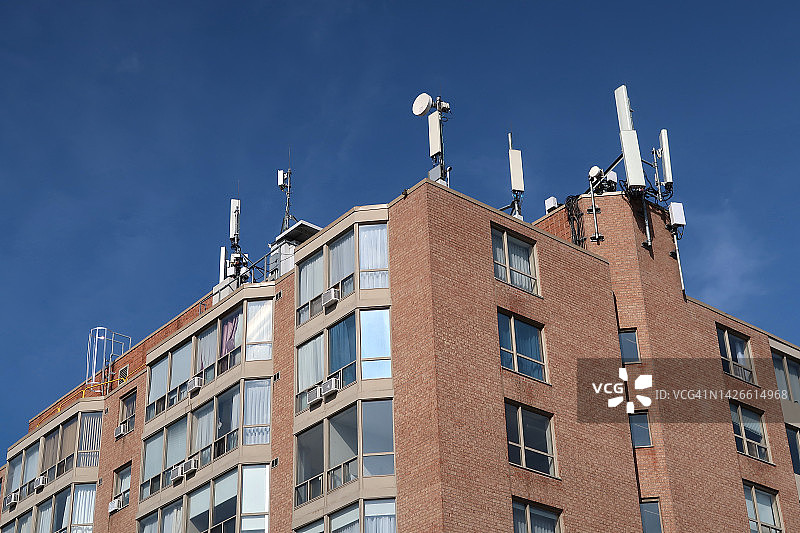 仰视楼顶安装无线设备的居民楼图片素材