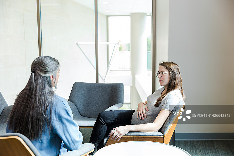 孕妇会见中年治疗师图片素材