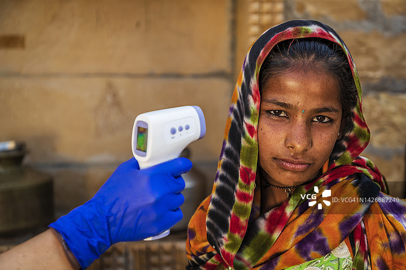 在印度偏远乡村，医生为病人测量体温图片素材