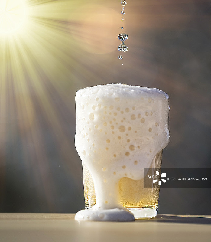 在阳光明媚的夏日倒入一杯啤酒图片素材