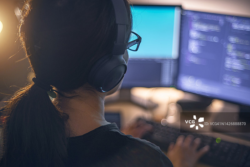 戴耳机在夜晚编程的女程序员图片素材