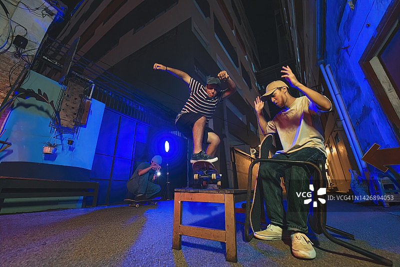 年轻人在后巷与朋友一起玩滑板图片素材