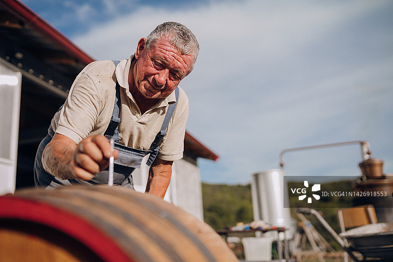 中年男人酿造白兰地图片素材