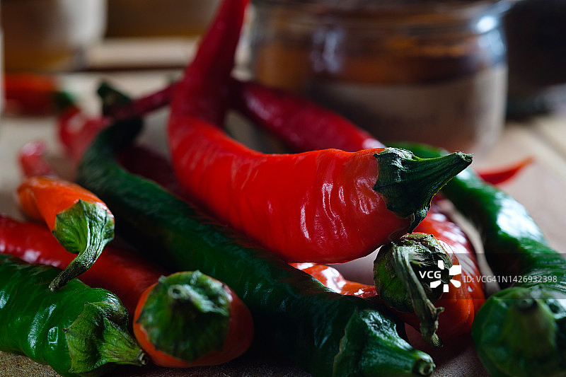 木桌上的红绿辣椒与香料罐图片素材