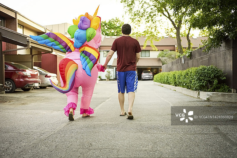 户外行走，穿着独角兽服装的人和男人图片素材