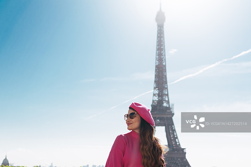 在巴黎埃菲尔铁塔下戴着巴黎帽的女人图片素材
