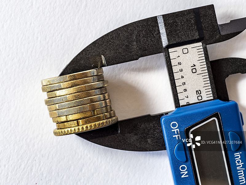 压力工具夹住一枚欧元硬币（白色背景）图片素材